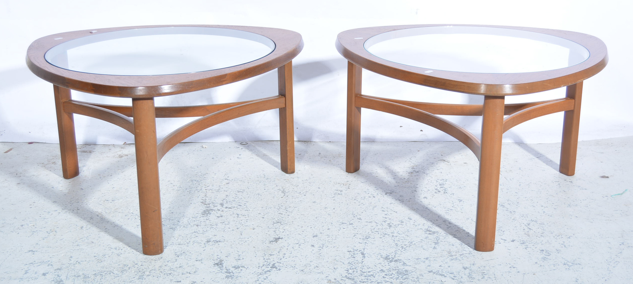 Pair of 1960s G-Plan style teak glass top tables, rounded triangular form,