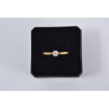 A diamond solitaire ring, the brilliant cut stone six claw set in a yellow and white gold mount,