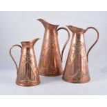 A set of three Art Nouveau copper graduating jugs, by Joseph Snakey & Sons,