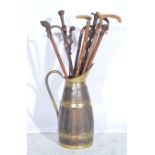 Collection of walking sticks in a coopered oak jug.