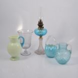 Collection of coloured glass jugs, pedestal oil lamp, and celery vase.