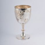 A large silver goblet, repousse chased with floral sprays around two vacant cartouches,