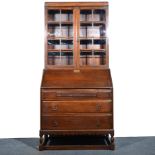 Oak bureau bookcase, panelled glass doors to the upper section enclosing shelves,