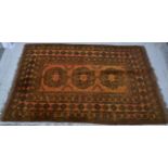 Afghan old gold rug, three central shaped tiles within broad floral design border.