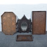 Three carved teak trays, two wall mirrors and two other carved panels.
