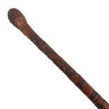 A Japanese bamboo walking cane with carved detail and lettering depicting flowers and figures,