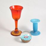 Four glass paperweights, a selection of coloured glass vessels,