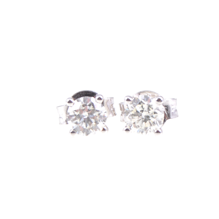 A pair of diamond single stone earrings, one brilliant cut diamond four claw set to each,