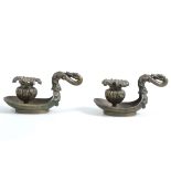 Pair of cast metal chambersticks, the handles formed as swan necks, 16cm wide,