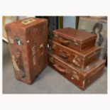 Four hard shell suitcases, varying sizes.