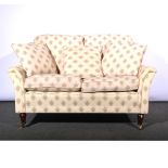 Modern high back two-seat sofa, floral medallions on cream ground, stained beech supports,