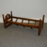 An antique mahogany childs rocking cradle with wooden slats,