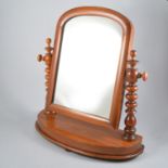 A mahogany framed swing toilet mirror, domed top with bobbin turned supports on a bow fronted base,