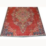 Old Hamadan rug, central floral medallion on a strawberry red ground, shaped spandrels, reduced,