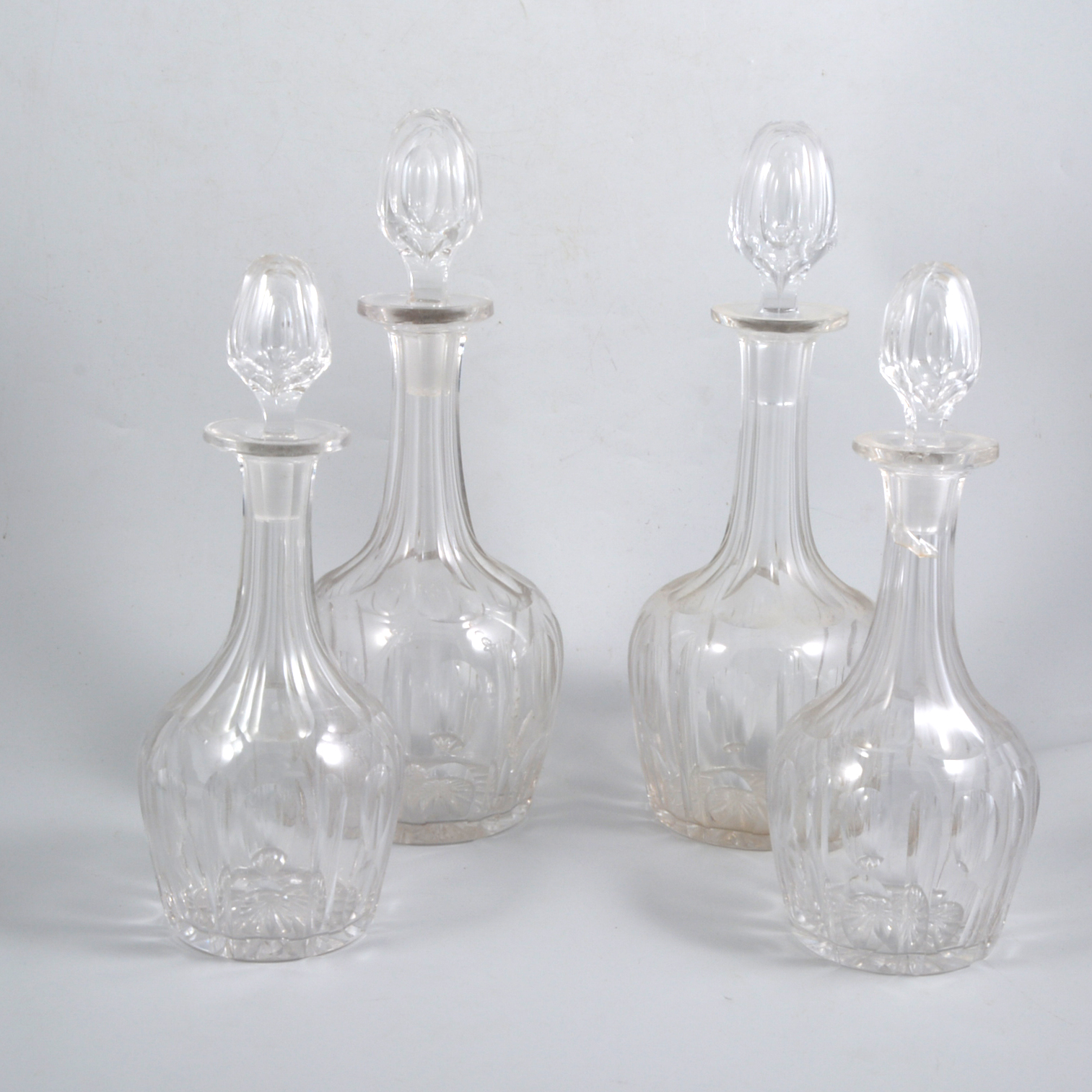 Two pairs of glass wine decanters each with narrow slender necks and concave fluting,