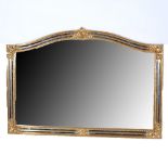 Contemporary over mantel mirror, Venetian style with an arched plate, scrolled corners, width 127cm,