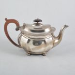 A silver teapot, plain polished oval panelled body with narrow fluted border all on four bun fet,