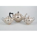 A white metal three piece teaset,