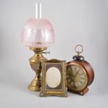 Continental walnut cased alarm mantel clock and two brass oil lamps; two photograph frames.