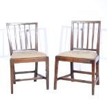 Four 19th Century oak rail-back dining chairs, needlework upholstered trap seats (one leg repaired).