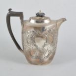 A Victorian Scottish oval silver hot water jug, repousse chased with floral and foliate decoration,