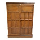 Gentlemans oak wardrobe/compendium, by Lee, Longland & Co, moulded cornice above two panelled doors,