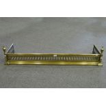 A brass fender with vertical fretwork and urn shaped finials, internal width 120cm.