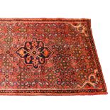 Hamadan runner, three medallions on a patterned red field, narrow border, 362 x 90cm.