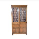 Oak bookcase, moulded cornice above leaded glazed doors enclosing adjustable shelves,