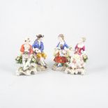 Pair of German porcelain figurines, of seated gardeners, 15cm; and another pair of gardeners.