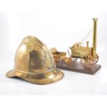 Brass fireman helmet, Stevenson's Rocket model, and other metal ware.