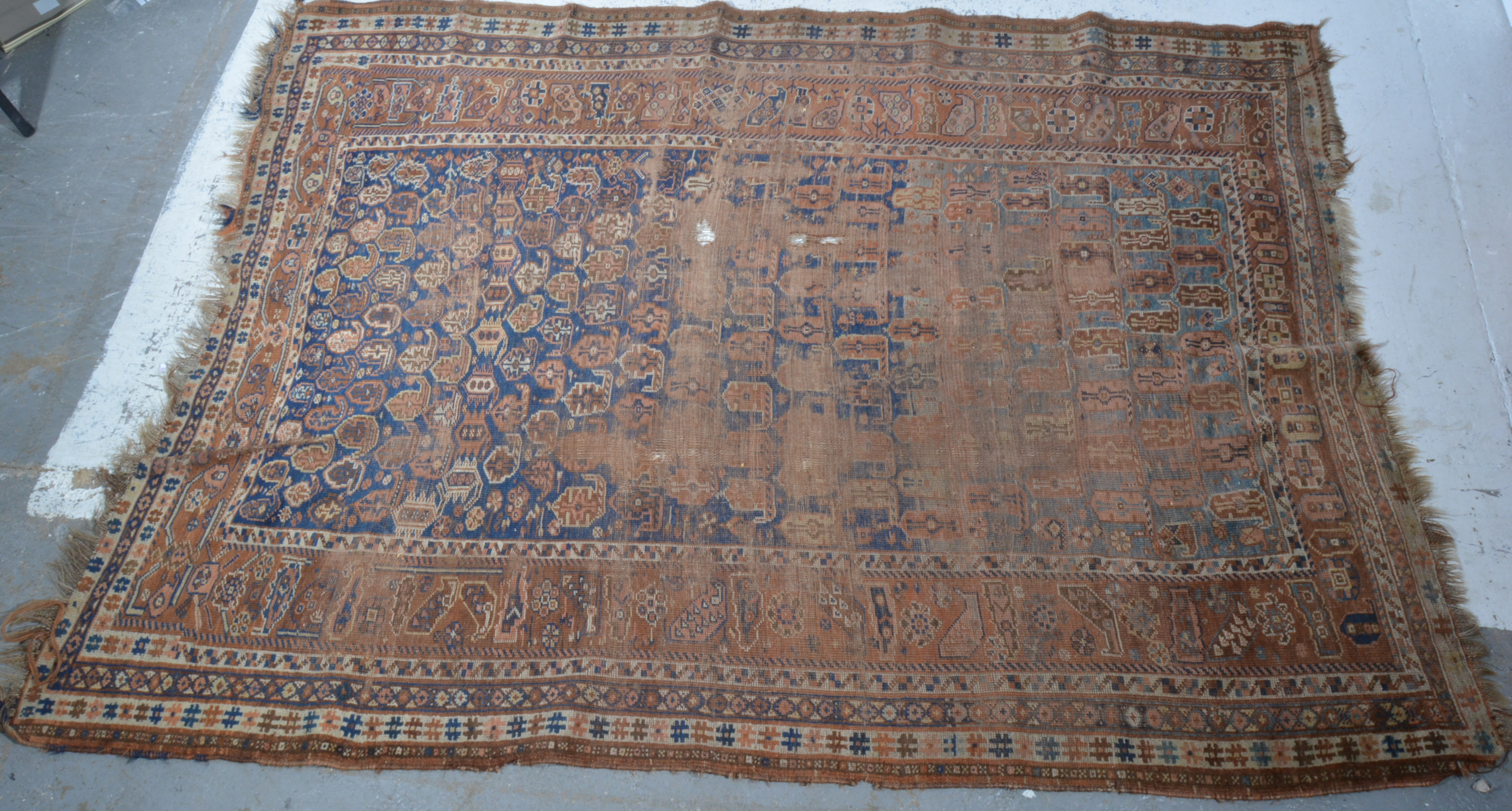 Old Persian rug, field with boteh motifs on a blue ground, multi-bordered, badly worn,