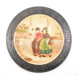 Bretby circular plaque, Dutch figures, diameter 38cm; and two similar oval plaques.