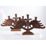 Pair of carved wooden double headed phoenix candlesticks, three light on rectangular bases,