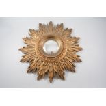 A sunburst gilded wood wall mirror, 44cm diameter with 10cm convex glass to centre,