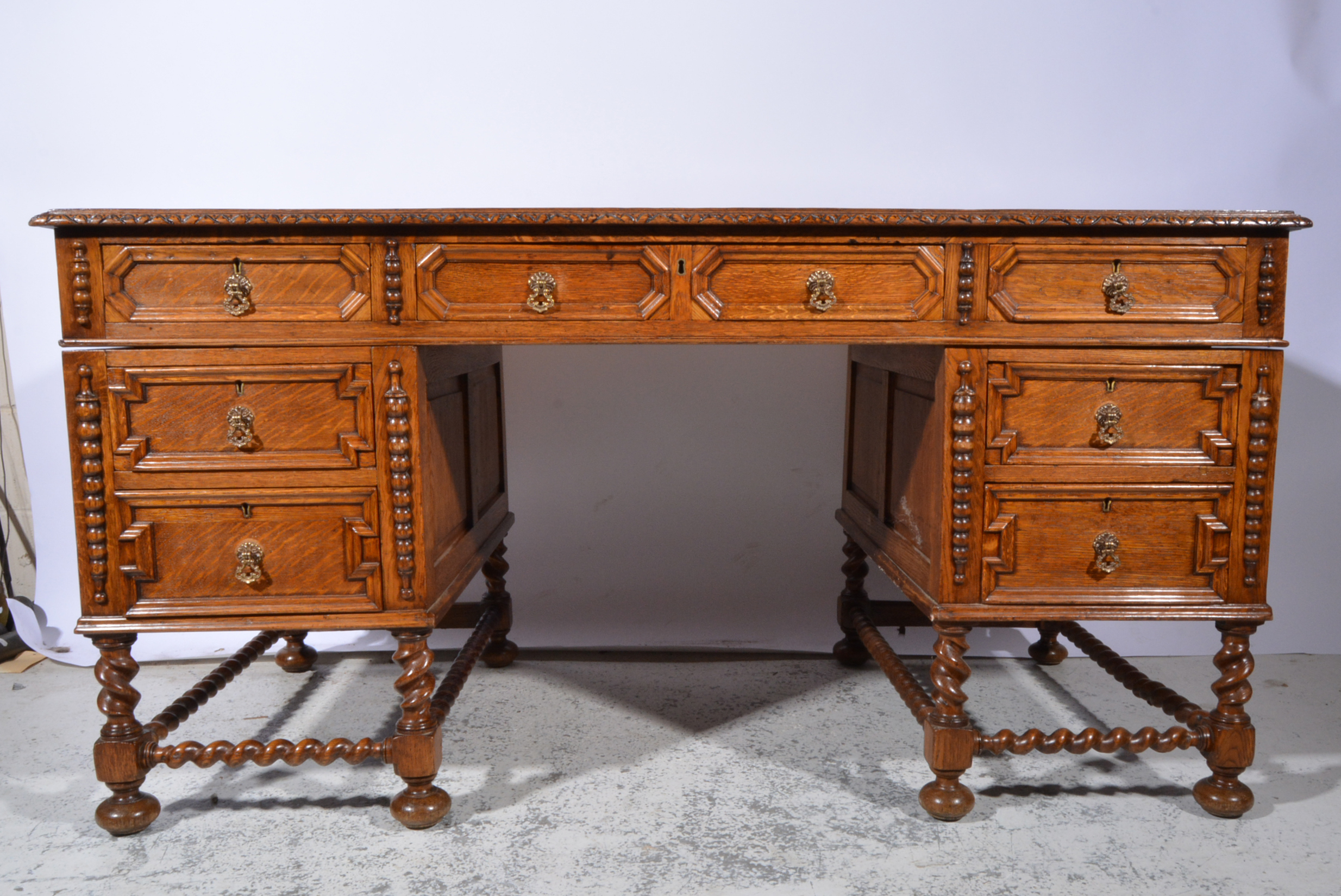 Oak desk, early 20th Century, rectangular top with a tooled and gilt leather inset, carved edge,
