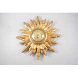 An early 20th Century gilded wood sunburst clock with brass French Japy Freres movement numbered