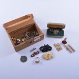 A small wooden box containing a gold-plated seal with intaglio base, a curb link bar brooch,