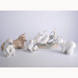 Five Lladro animal figurines, polar bears, geese and a cat, a Nao recumbant cow.