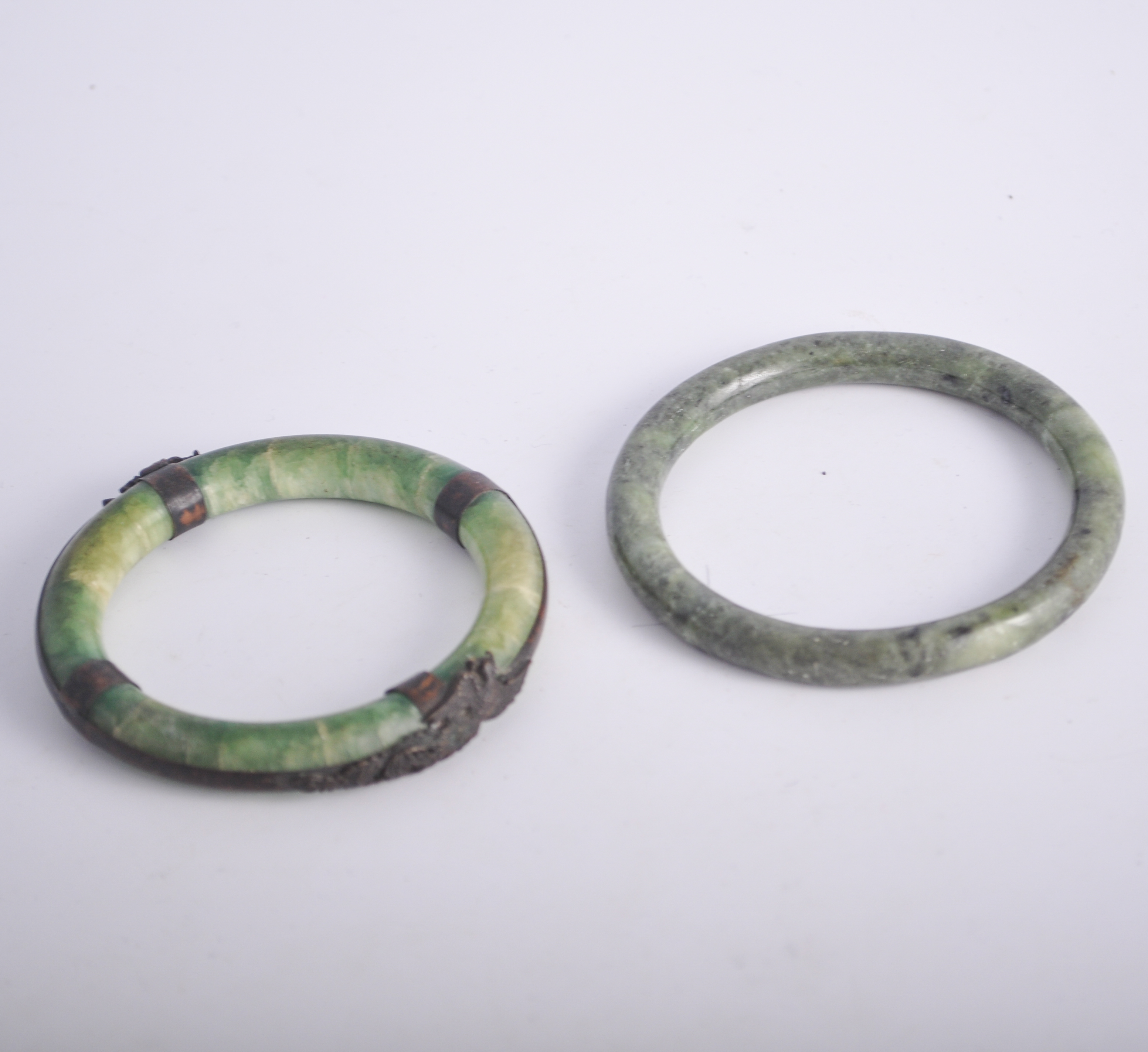 Metal mounted Jadeite bangle, and another Jadeite bangle.