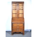 1940s oak bureau bookcase, the upper section with two glazed doors enclosing adjustable shelves,