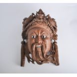 Carved hardwood mask, probably Bali, the figure with a dragon headdress, 32cm.