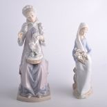 Two Lladro figures, a girl seated with lilies 23cm high and and a lady in period costume sewing,