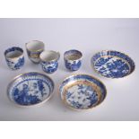 Collection of blue and white tea bowls and saucers, mostly with gilt outlines.