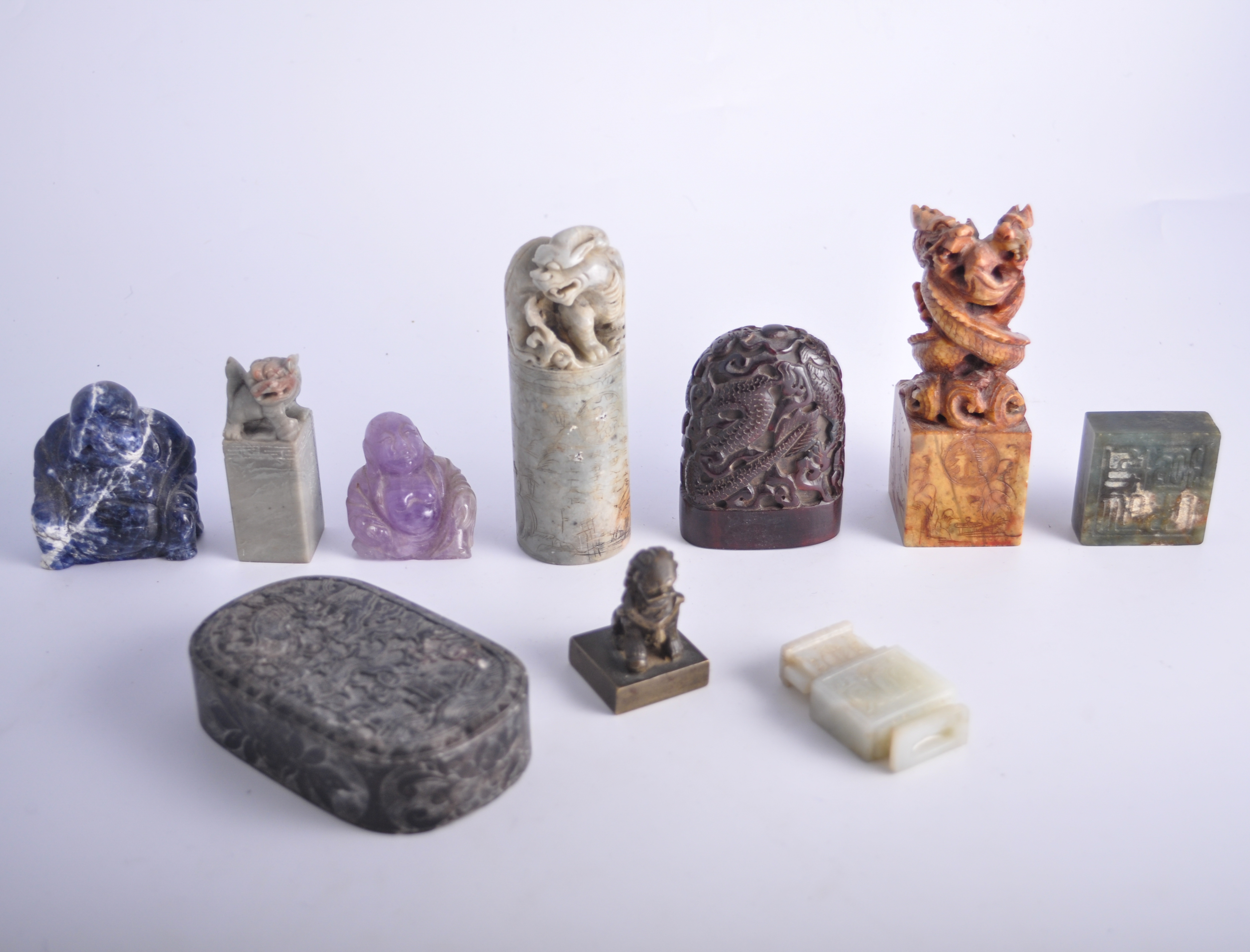 Three carved soap stone seals; a Lapis coloured model of Buddha,