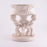 A reproduction parian bowl supported by three putti in the Clodion style 28cm high and two
