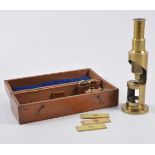 Lacquered brass student's microscope, 15cm, in a fitted mahogany case.