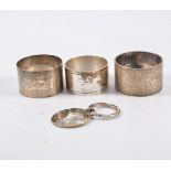 Three silver napkin rings, two engine turned, and a keyring.