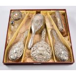 Part dressing table set; including hand mirror and brushes, embossed with scrolls,