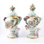 Pair of Meissen style urns, early 20th Century encrusted with flowers, fruit and cherubs,